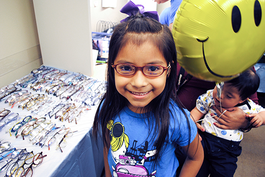 Child receiving glasses from iCare4Kids Vision Program