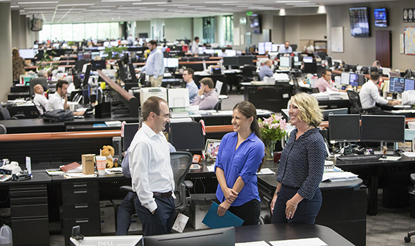 Photo of three people talking in an office setting