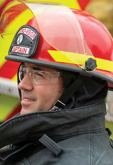 A man wears fire protective clothing and a hard hat.
