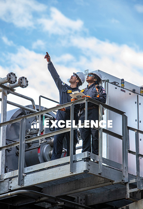 Two Valero employees inspect equipment at a refinery. Text reads: Excellence.