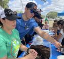 Valero volunteers hand out dirt to children for earth day event