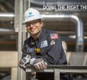 Refinery engineer smiling in hardhat and safety gear on a unit platform