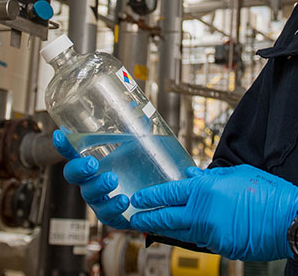 Valero employee holding jar of ethanol
