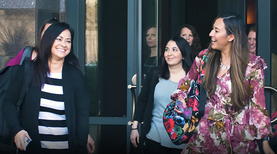 Happy employees walking in a group together on campus