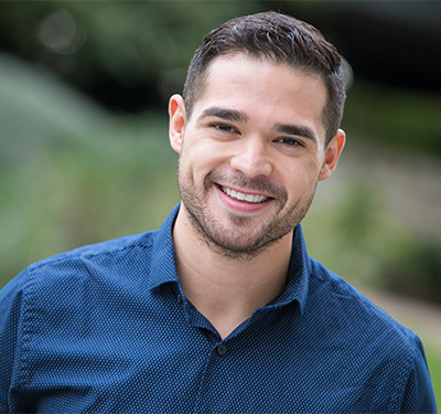 Headshot of man outdoors smiling at camera