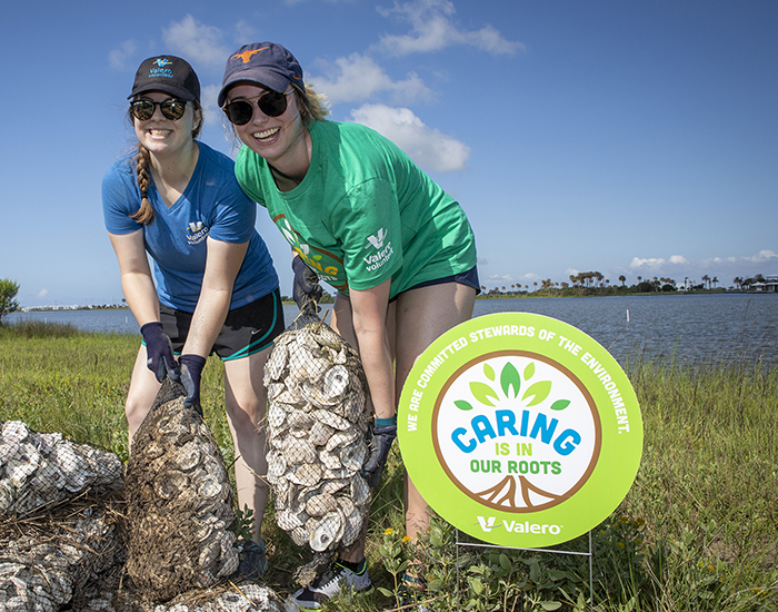 Volunteers hold bags of recycled oyster shells