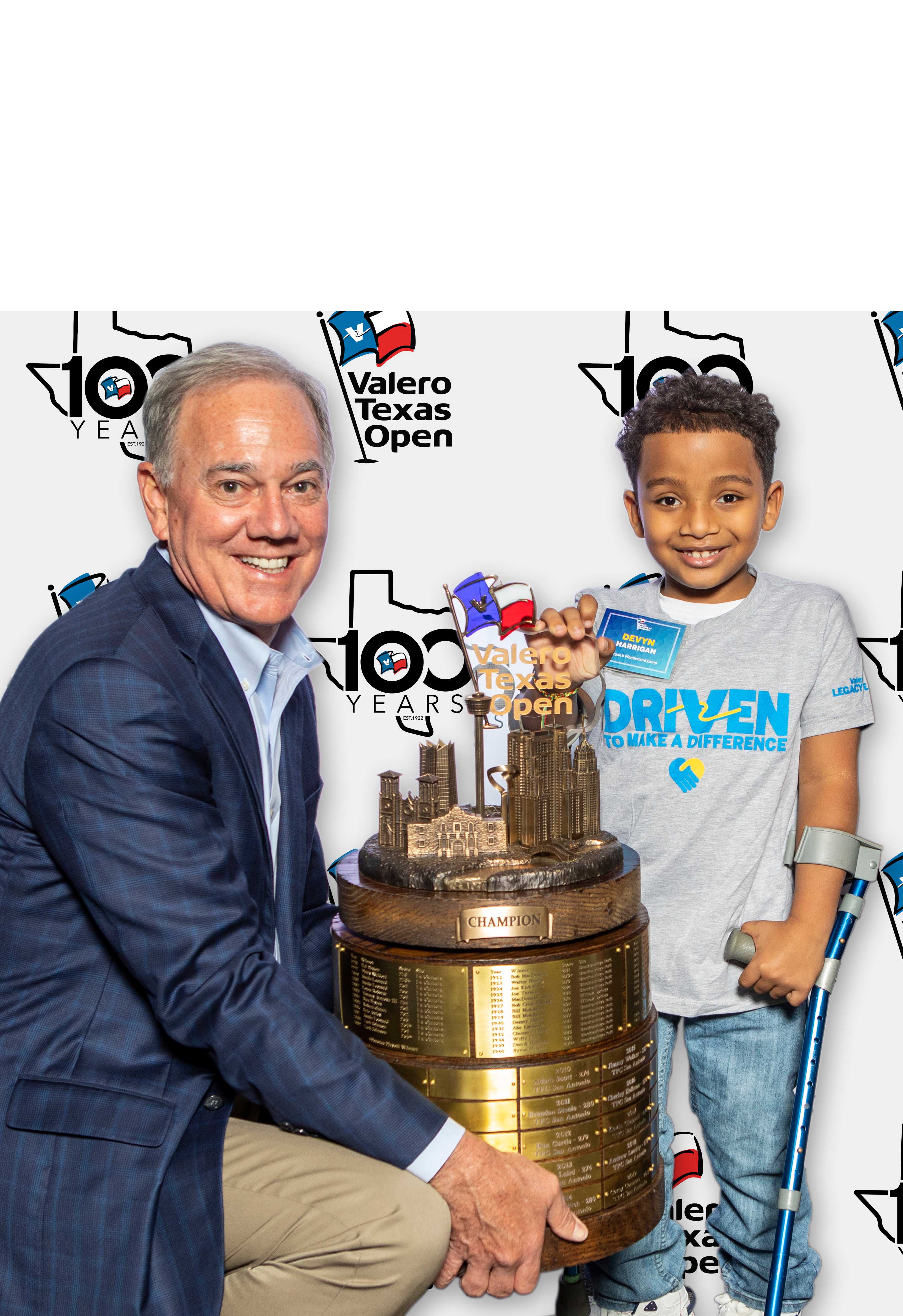 CEO Joe Gorder holding trophy next to young boy