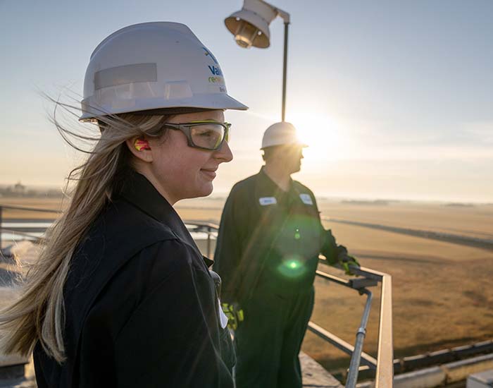 Two Valero employees stand in the sunrise.