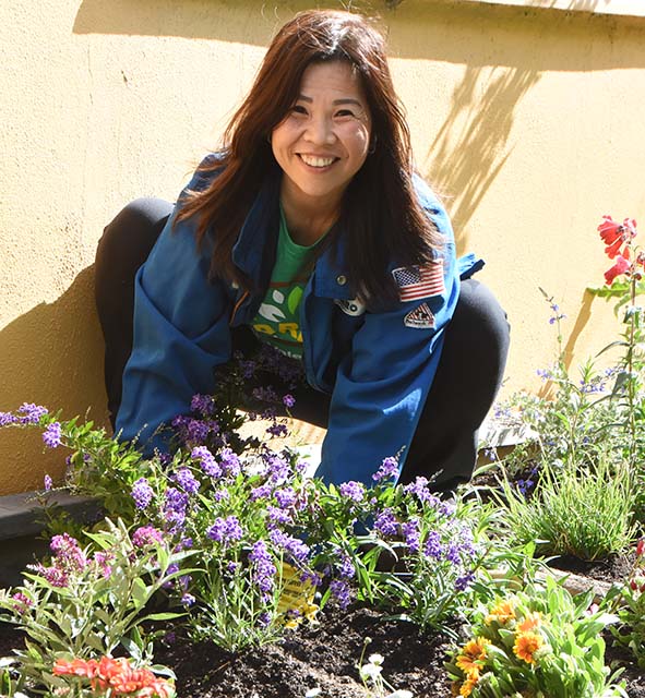 Refinery employee planting a colorful garden at a volunteer event.