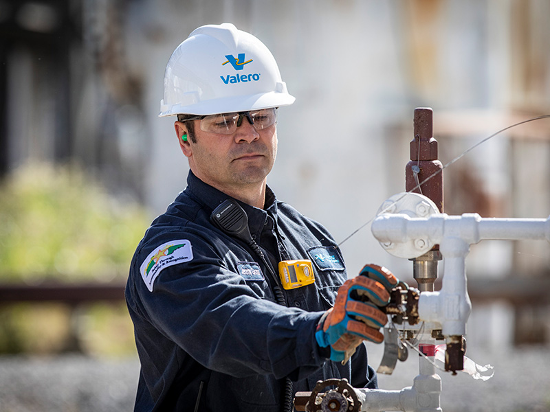 Employee checking refinery equipment