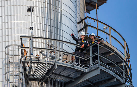 Two Valero employees inspect equipment at a refinery.