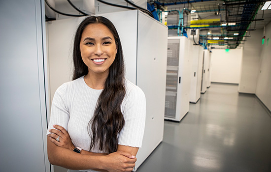 A Valero employee stands with computer equipment.