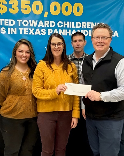 Valero employees donate a check to charity.