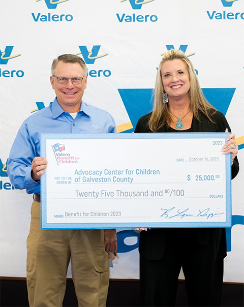 Valero employees hold an oversize check donation to charity.