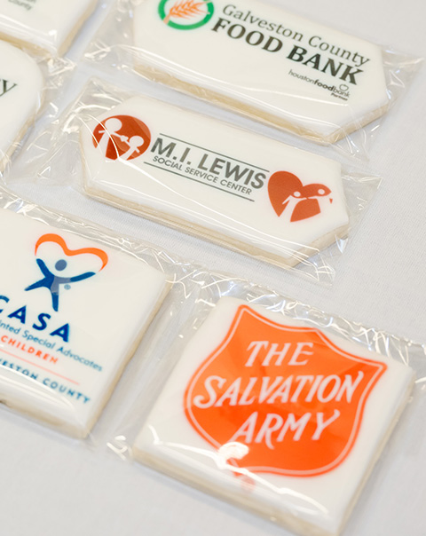 Charity-branded cookies bear the names of the Child Advocacy Center, Galveston County Food Bank, M.I. Lewis Social Service Center, CASA - Court Appointed Special Advocates for Children, and The Salvation Army.