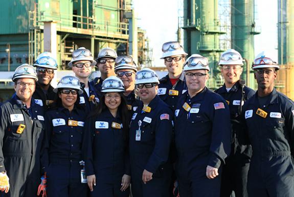Operators grouped together near a refinery