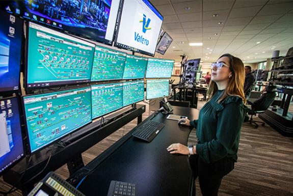 Woman working, looking at multiple tv monitors