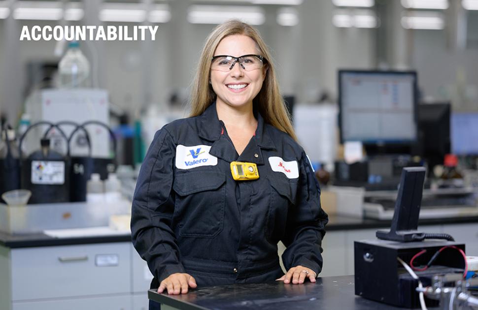 Employee stands looking proud near laboratory equipment