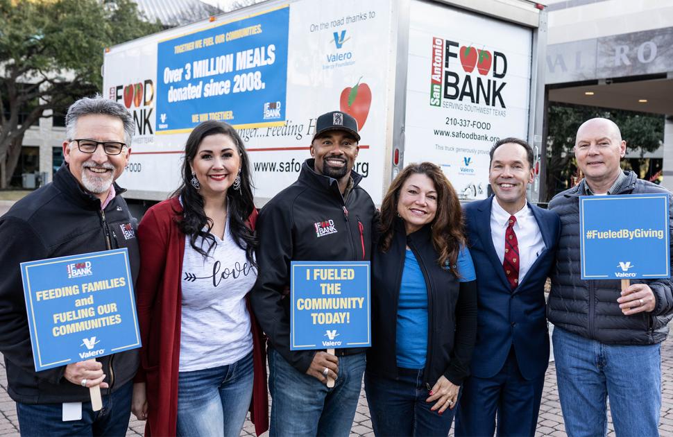 Volunteers stand next to a San Antonio Food Bank truck.
