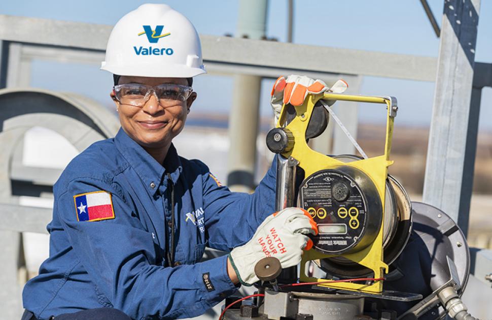 Woman working with a machine, smiling at camera