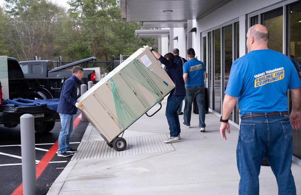 Volunteers moving heavy household appliances