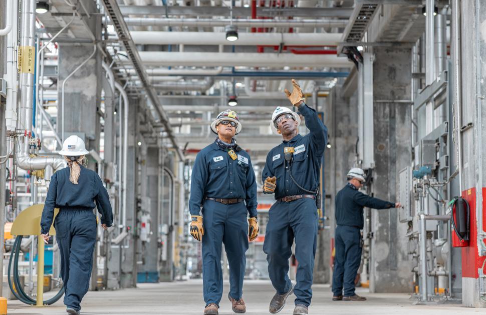 Employees walking through refinery units