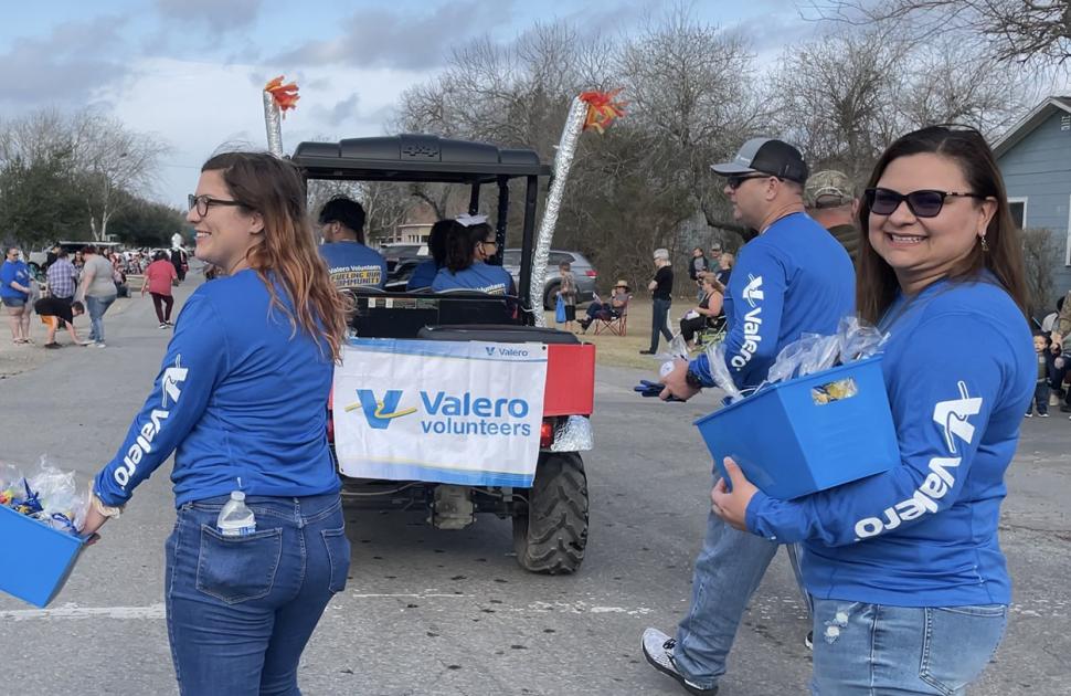 Valero volunteers during a parade, handing out goodies