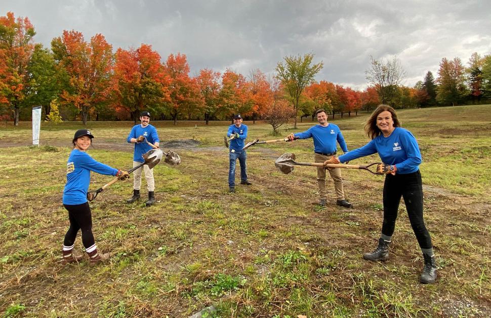 Valero Volunteers hold shovels in a field at a volunteer event