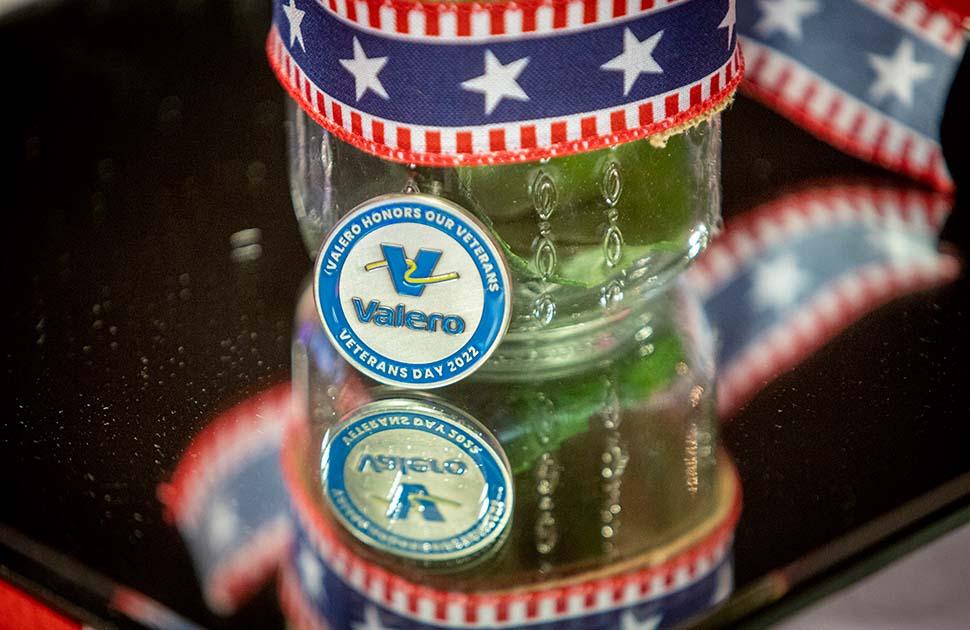 A Valero challenge coin and red, white and blue ribbon decorate a table during Veterans Day 2022.