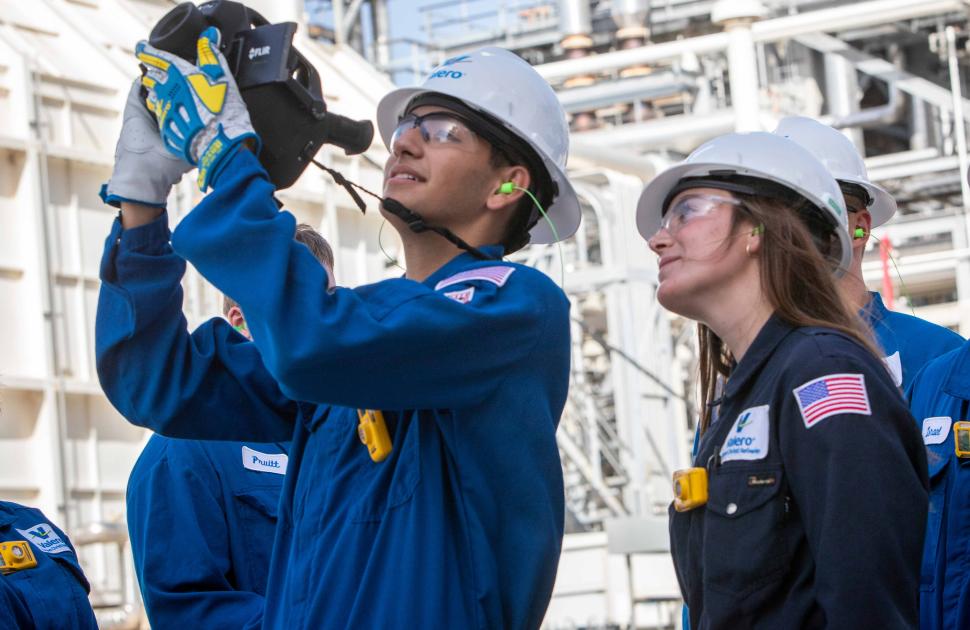 Interns at a refinery looking through a radar/camera.