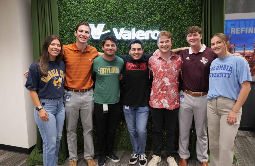 Group of interns posed at a photo booth in their respective school shirts.