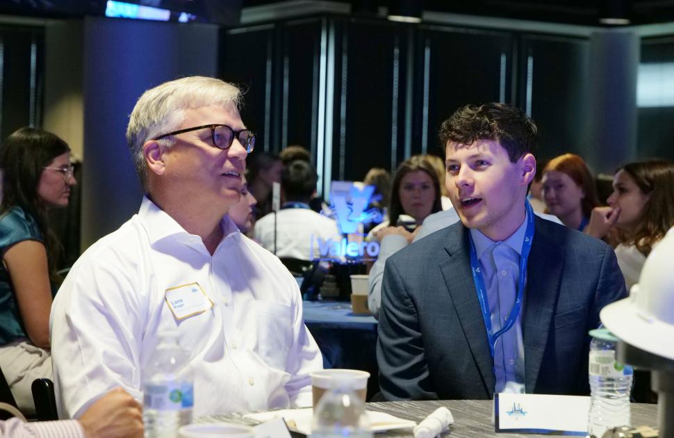 Intern seated and conversating with Valero's President and CEO, Lane Riggs.