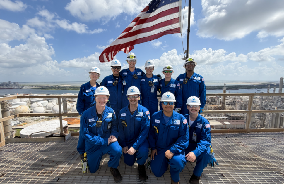 Group of Corpus Christi Interns with American flag behind 