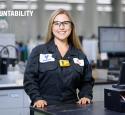 Employee stands looking proud near laboratory equipment