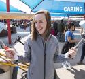 Employee volunteer with paint rollers smiling at an event