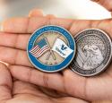 Photo of hands holding the two Valero Veteran coins