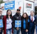 Volunteers stand next to a San Antonio Food Bank truck.