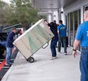 Volunteers moving heavy household appliances
