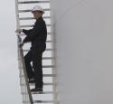 Person climbing ladder at McKee Refinery