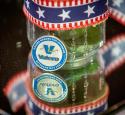 A Valero challenge coin and red, white and blue ribbon decorate a table during Veterans Day 2022.