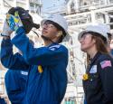 Interns at a refinery looking through a radar/camera.