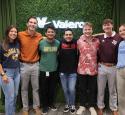 Group of interns posed at a photo booth in their respective school shirts.