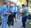 Valero volunteers at a public park give backpacks filled with essentials to those in need.