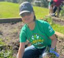 A Valero volunteer pulls weeds in a community garden.