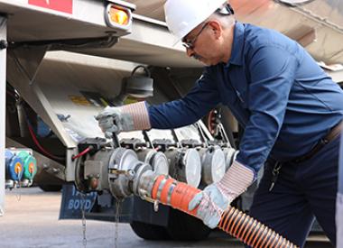 Valero truck driver attaching hose to tanker