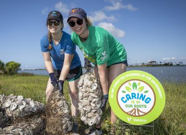 Volunteers hold bags of recycled oyster shells
