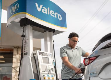 Man Pumping Gas at Station