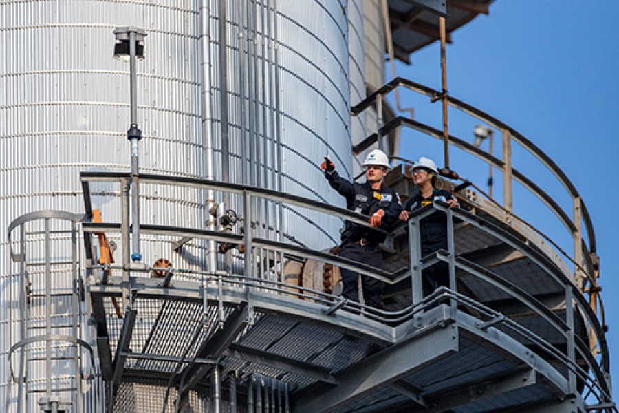 Two Valero employees inspect equipment at a refinery.