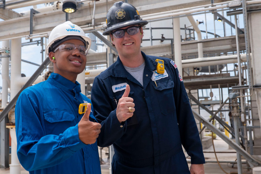 Summit participant with Valero employee giving thumbs up while at the refinery.